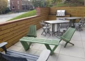 Thumbnail 17 of 19 - a patio with a table and chairs and a grill